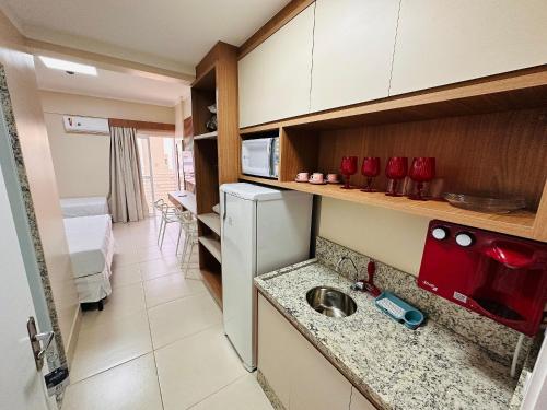 een kleine keuken met een wastafel en een koelkast bij Spazzio diRoma in Caldas Novas