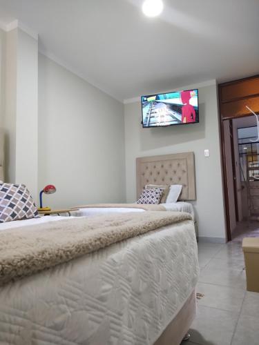 2 camas en una habitación con TV en la pared en SHUMAQ YUNGAY - Depas en Yungay