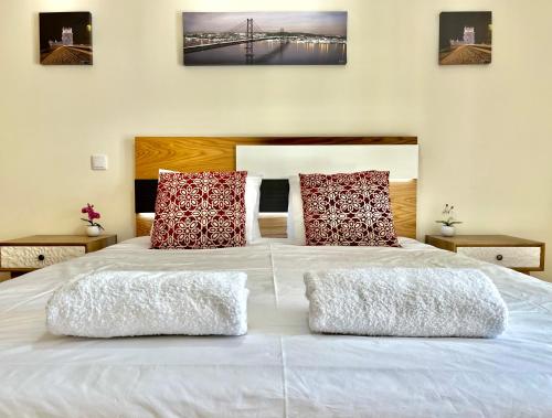 a large white bed with two pillows on it at Modern & Spacious APT with River View in Lisbon