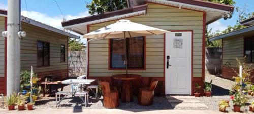 a small house with a table and an umbrella at Homey Inn-Olango Island Staycation ,block 1 lot 15 in Lapu Lapu City