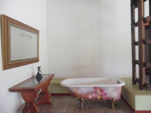 eine Badewanne neben einem Tisch und einem Spiegel in der Unterkunft Finca familiar privada para el descanso in Puerto Triunfo