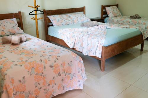 a bedroom with two beds with flowers on them at pousada Anna Assumpta in Severínia