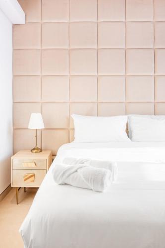 two beds with white sheets and a night stand with a lamp at Premium 2+1 BR condo in the heart of Bluewaters Island in Dubai