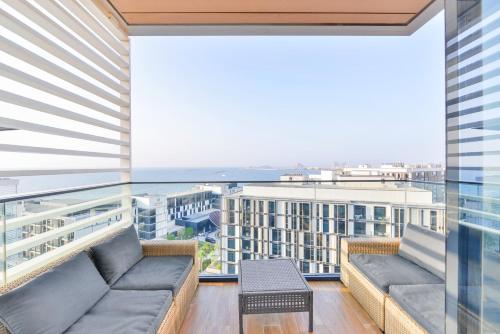 a balcony with couches and a view of the ocean at Premium 2+1 BR condo in the heart of Bluewaters Island in Dubai
