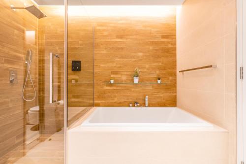 a bathroom with a large tub and a shower at Premium 2+1 BR condo in the heart of Bluewaters Island in Dubai