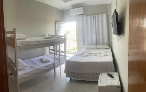 a room with two bunk beds and a television at Hotel Shalom in Juazeiro do Norte