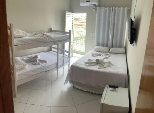 two bunk beds in a room with a window at Hotel Shalom in Juazeiro do Norte