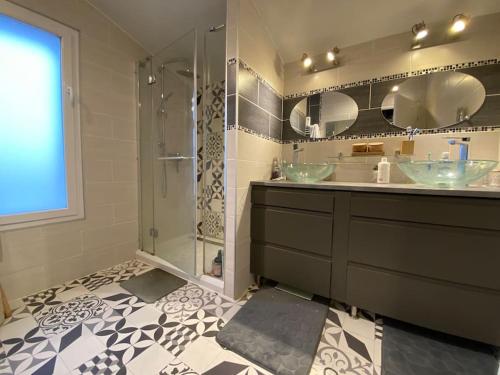 ein Badezimmer mit zwei Waschbecken und einer Glasdusche in der Unterkunft Villa contemporaine avec piscine in Romans-sur-Isère