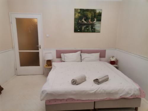 a bedroom with a large bed with two objects on it at Malomszeg Apartman in Pécs