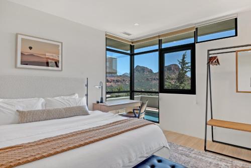 - une chambre avec un lit, un bureau et des fenêtres dans l'établissement Painted Red Rock Skies with 180 degree Panoramic Views, Private Pool & Hot Tub!, à Sedona