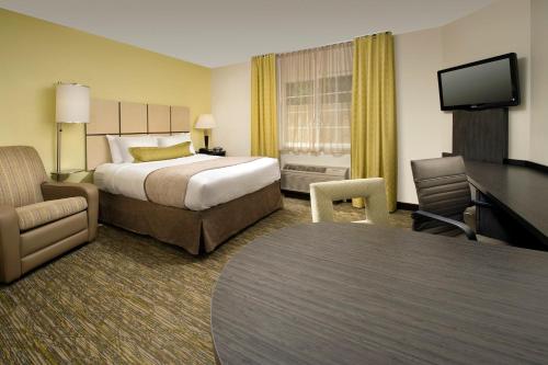 a hotel room with a bed and a desk at Candlewood Suites Richmond - South, an IHG Hotel in Richmond