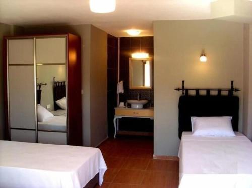 a bedroom with two beds and a bathroom with a sink at TARiH OTEL NEMRUT DAGI in Karadut