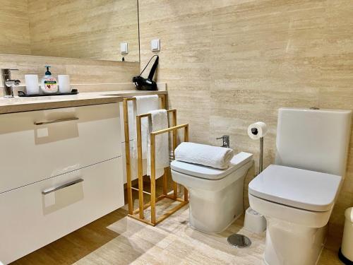 a bathroom with a white toilet and a sink at Modern & Spacious APT with River View in Lisbon