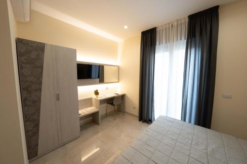 a bedroom with a bed and a desk and a window at Hotel Auditorium in Bari