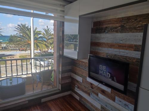 sala de estar con TV y vistas a la playa en APARTAMENTO EN LINEA DE PLAYA, en Suances