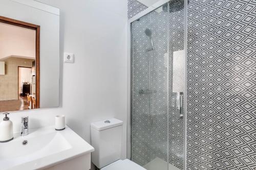 a bathroom with a shower and a toilet and a sink at Casa Delgado in Tavira