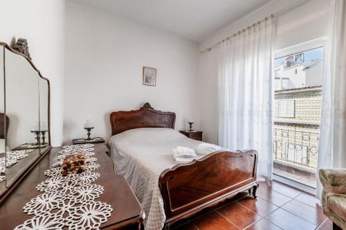 a bedroom with a bed and a large window at Casa Delgado in Tavira