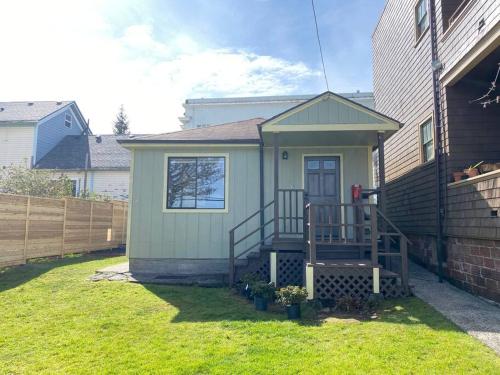 a small house with a staircase in a yard at Quaint Downtown Cottage in Astoria, Oregon
