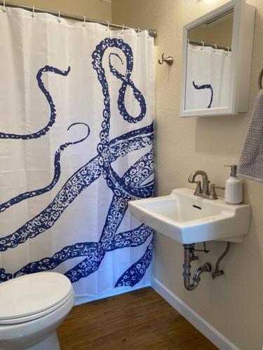 a bathroom with a blue and white shower curtain at Quaint Downtown Cottage in Astoria, Oregon