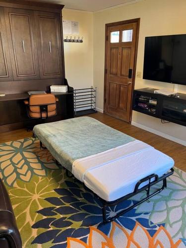 a room with a bed and a flat screen tv at Quaint Downtown Cottage in Astoria, Oregon