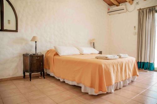 een slaapkamer met een bed met een oranje laken erop bij Casa de Campo Kagua Kolke 8Pax By Inside in Tupungato