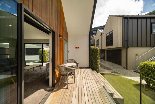 a wooden deck with a chair on a house at Home Away from Home in Queenstown