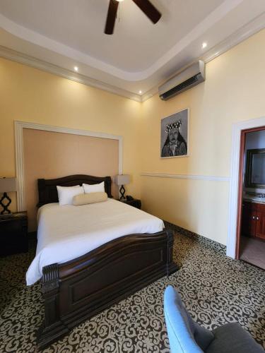 a bedroom with a bed and a chair in it at Hotel la Perla Leon in León