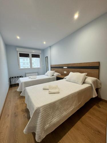 ビジャルバにあるCortiñasのベッド3台と窓が備わる客室です。
