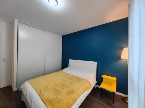 a bedroom with a bed and a blue wall at sacha's house ,à coté du RER,val d'europe,Paris-Disney . in Bussy-Saint-Georges