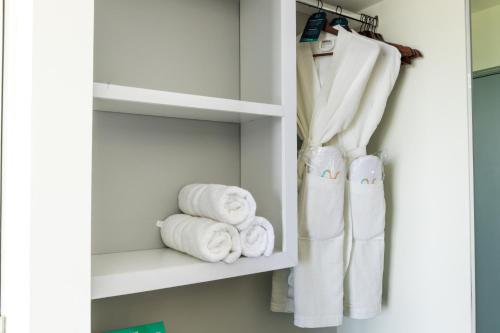 baño con toallas blancas en un estante en Oceana Resort & Conventions, en Monterrico