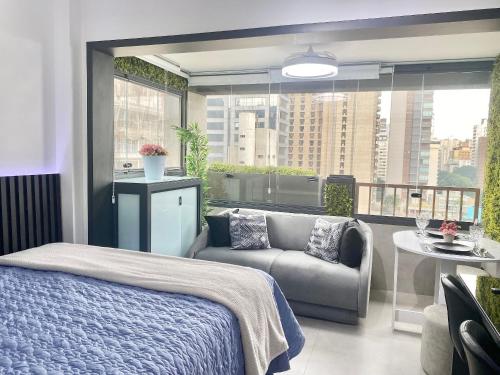 a bedroom with a bed and a couch and a balcony at Ap luxo Jardins Pamplona cd 1111 in Sao Paulo