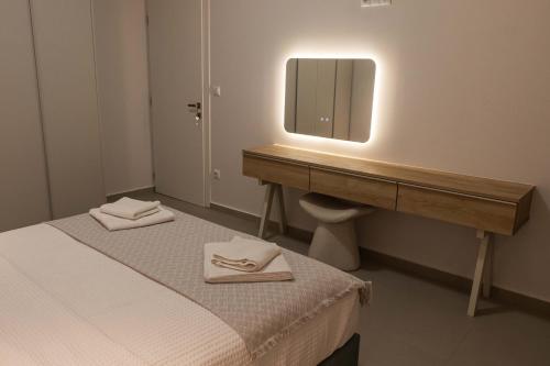 baño con cama y tocador con espejo en Harmony Luxury Apartment, en Ierápetra