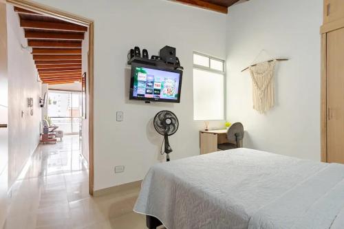 1 dormitorio con 1 cama y TV en la pared en Hermoso apartamento en Sabaneta cerca al parque, en Sabaneta