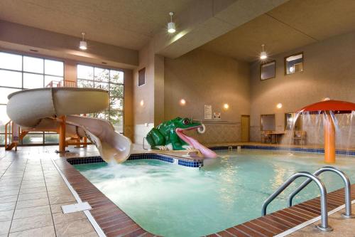 una piscina cubierta con un tobogán en una habitación de hotel en ClubHouse Hotel Sioux Falls, en Sioux Falls