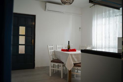 ein Esszimmer mit einem Tisch, Stühlen und einer schwarzen Tür in der Unterkunft Apartments Josipa in Primošten