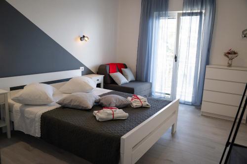 ein Schlafzimmer mit einem Bett mit zwei Kissen und einem Stuhl in der Unterkunft Apartments Josipa in Primošten