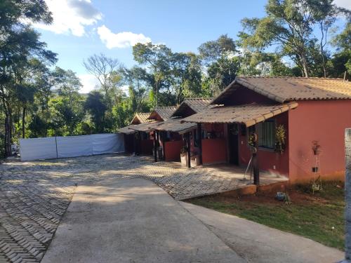uma casa com uma cerca branca em frente em Pousada Rota dos Macacos em Nova Lima