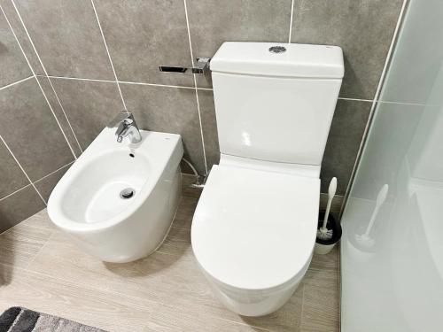 a bathroom with a white toilet and a bidet at Relaxing Ocean View, Spacious Art Apartment With Large Terrace, Near Best Costa Adeje Beaches in Adeje