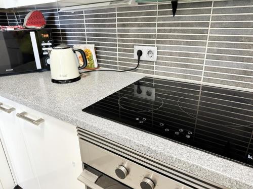 a kitchen counter with a toaster and a stove at Relaxing Ocean View, Spacious Art Apartment With Large Terrace, Near Best Costa Adeje Beaches in Adeje