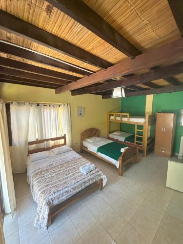 a bedroom with two beds and two bunk beds at Punta Pacífico Bungalows Máncora in Máncora