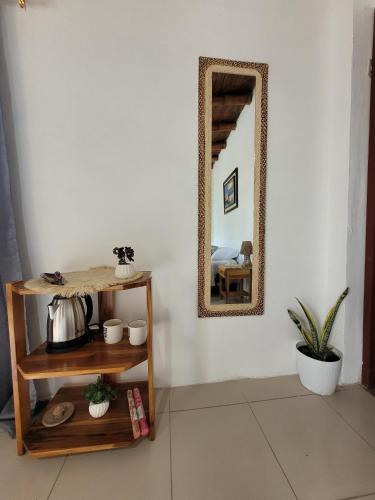 a mirror on a wall in a room with a table at Palmendros Hosteria in Montañita