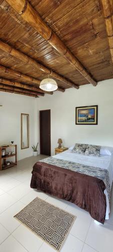 a bedroom with a large bed and a wooden ceiling at Palmendros Hosteria in Montañita