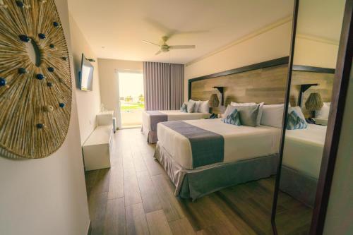 Habitación de hotel con 2 camas y espejo en Oceana Resort & Conventions, en Monterrico