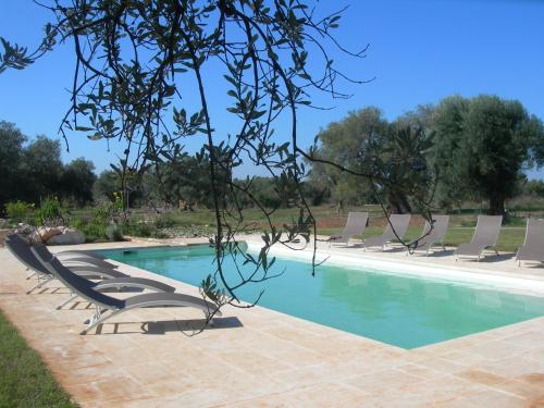 a swimming pool with lounge chairs and a swimming pool at Agriturismo Spirdo in Ruffano