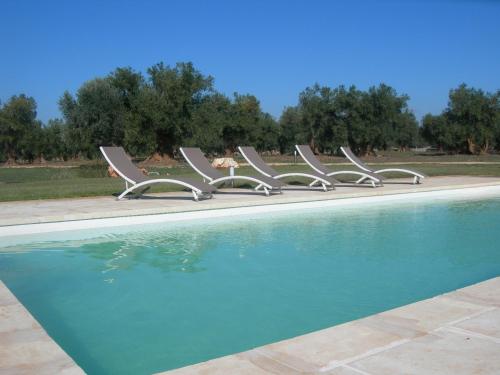 a row of chairs sitting next to a swimming pool at Agriturismo Spirdo in Ruffano