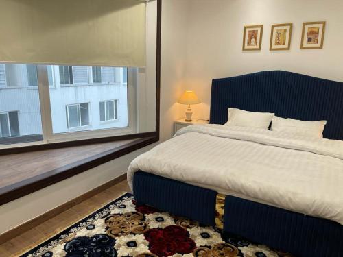 een slaapkamer met een groot bed en een raam bij Premium&Cozy Studio DHA Lahore in Lahore