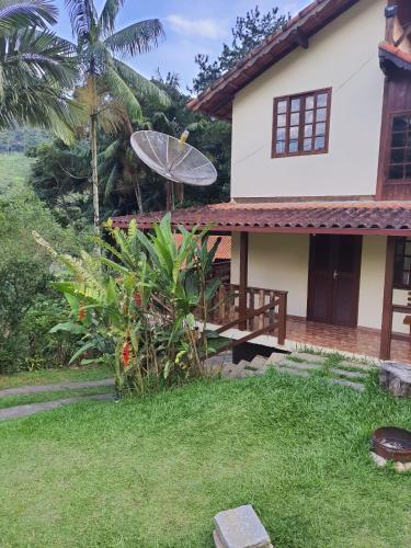 a house with an umbrella in the yard at Chalé Lumiar M&C in Lumiar