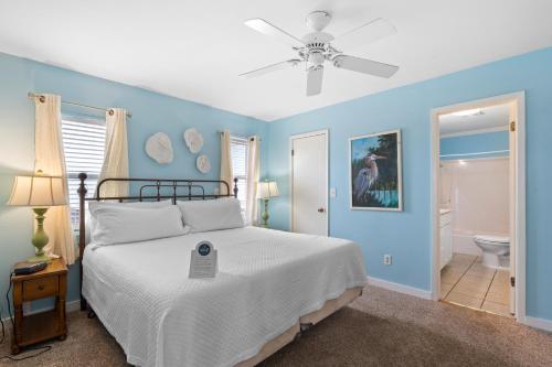 um quarto com paredes azuis e uma cama com uma ventoinha de tecto em Gulf Front Beach House Sleeps 12 em Gulf Shores