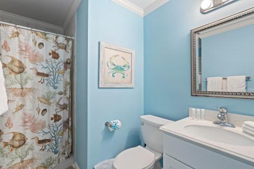 uma casa de banho com um WC, um lavatório e um espelho. em Gulf Front Beach House Sleeps 12 em Gulf Shores