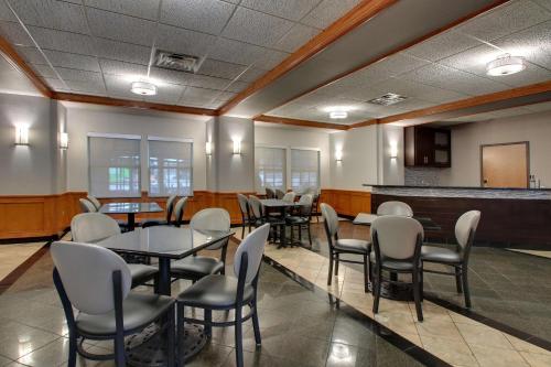a dining room with tables and chairs and a bar at Drury Inn & Suites San Antonio Northwest Medical Center in San Antonio